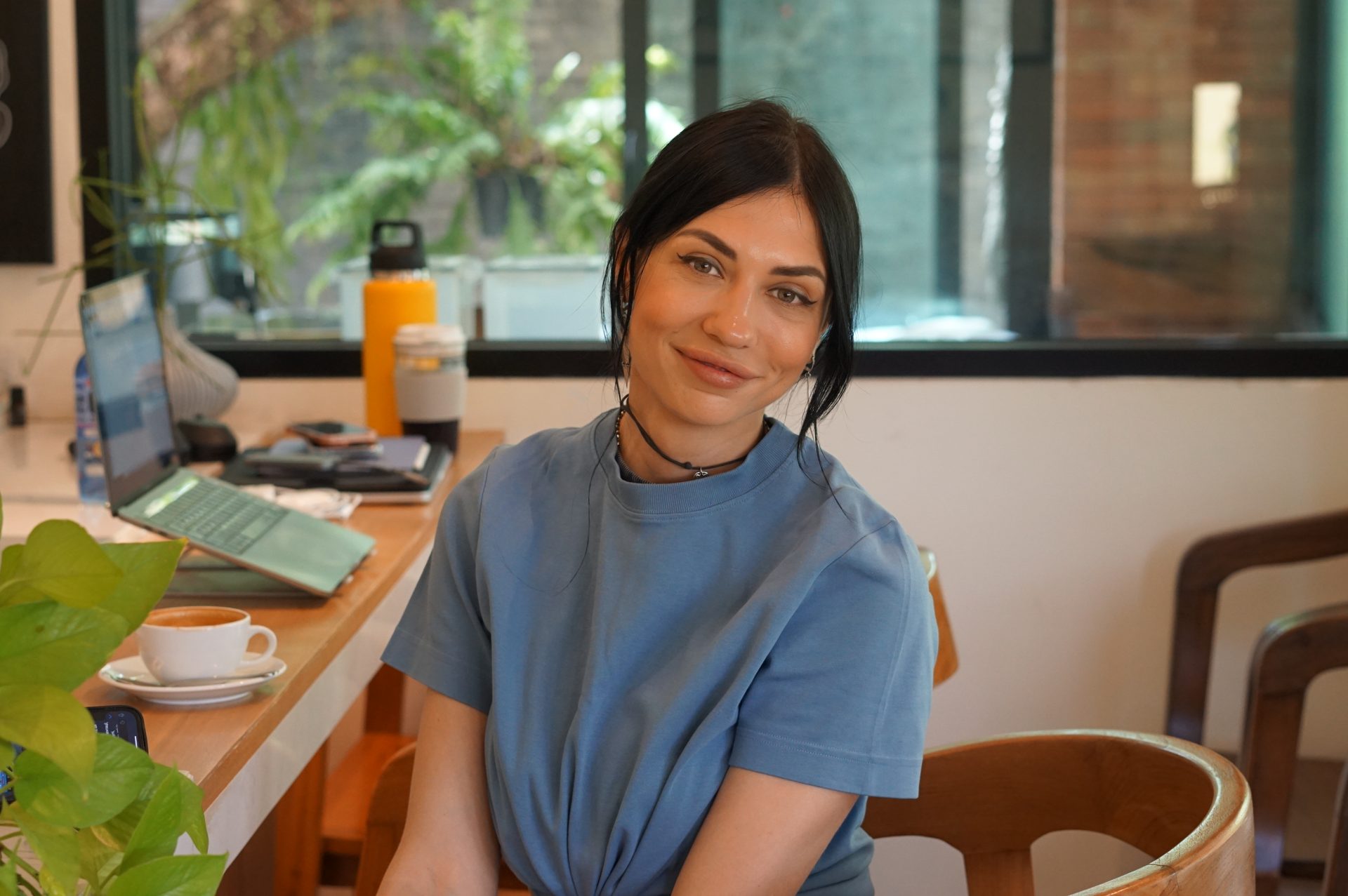 Smiling woman working on a laptop in a cafe